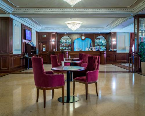 a restaurant with tables and chairs and a bar at Radisson Hotel Astana in Astana