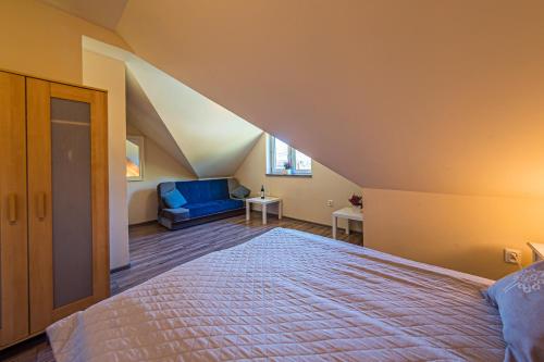 a bedroom with a large bed and a blue couch at Solna Chata-dom na wyłączność Grota solna, balia, sauna, basen in Rajcza