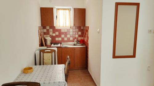a small kitchen with a table and a sink at Resort "Maslinjak" in Budva