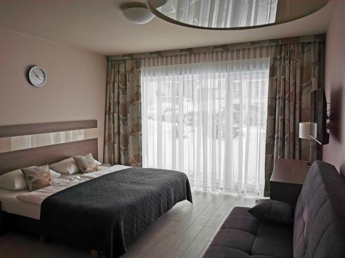 ein Schlafzimmer mit einem Bett und einem großen Fenster in der Unterkunft Apartament Czarna Góra TIGNES 4 Sienna in Heudorf