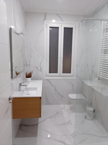 a white bathroom with a sink and a toilet at URDAIHOME in Guernica y Luno