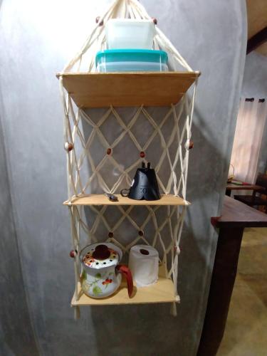 a shelf with pots and pans and a teapot at Chalé 03 Itaipu Vale da Colina Niterói in Niterói