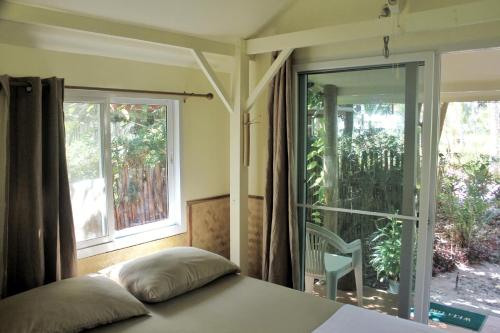 a bedroom with a bed and a large window at Pink Kangaroo Bungalows in Ko Kood