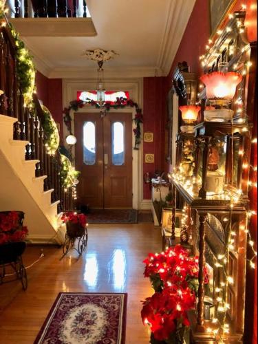 a living room with christmas lights and a door at Raindrops On Roses Bed & Breakfast in Herkimer