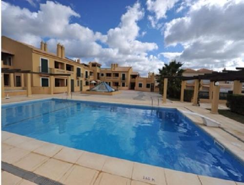 una gran piscina de agua azul en un patio en Vila Bairos Apartment Vilamoura, en Vilamoura