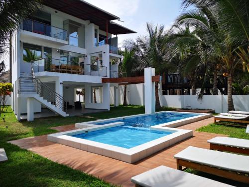 a house with a swimming pool in front of a house at Casa de Mateo - Zorritos - Tumbes in Zorritos