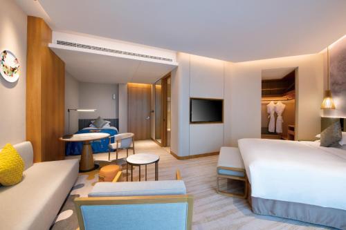een hotelkamer met een bed en een woonkamer bij Crowne Plaza Huzhou by IHG in Huzhou