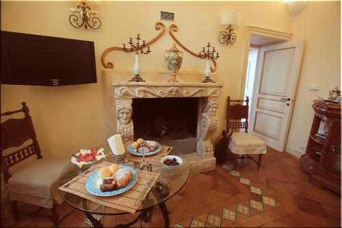 a living room with a fireplace and a table with food at Villa Alba d'Oro - Historic luxury villa in Amalfi