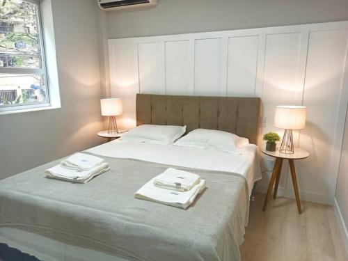 a bedroom with a large bed with two lamps at Apto amplo Aconchegante 3Qts, TV 65, Ar Cond Ótima localização in Maringá
