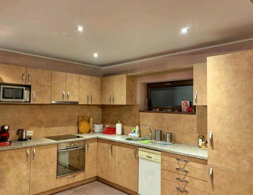 a large kitchen with wooden cabinets and a sink at Puzzle House and Nature in Talea