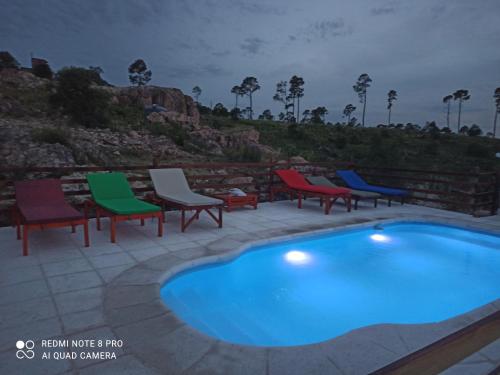 a group of chairs and a swimming pool at Cabañas PAIGÜEN in Villa Yacanto