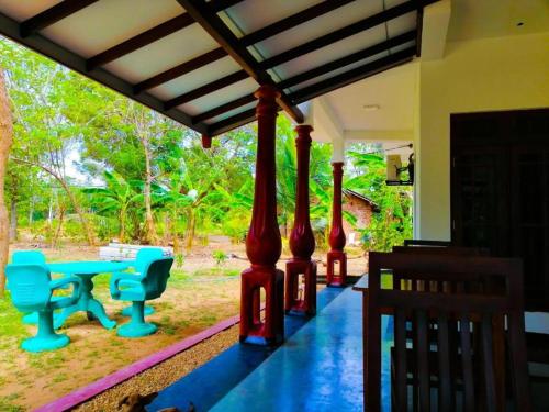 a porch with two blue benches and a table at Ethili Lake view & Safari Camp in Wellawaya