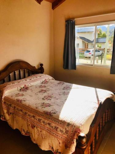 a bed sitting in a bedroom with a window at La posada de Icha in El Bolsón
