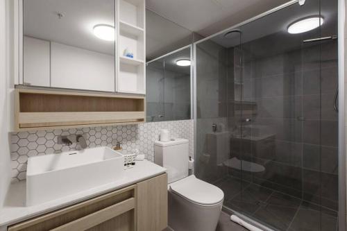 a bathroom with a toilet and a sink and a shower at Resort Style Living In the Heart of Moonee Ponds in Melbourne