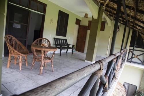 a porch with chairs and a table on a house at Beach Front Guesthouse in Puerto Escondido