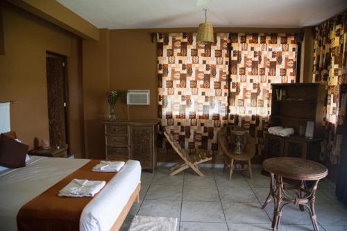 a bedroom with a bed and a table and chairs at Beach Front Guesthouse in Puerto Escondido