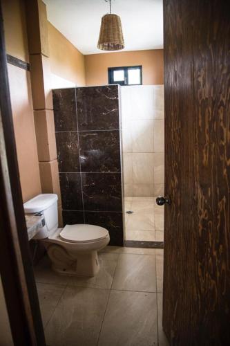 a bathroom with a toilet and a shower at Beach Front Guesthouse in Puerto Escondido