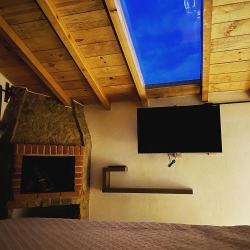 a flat screen tv on a wall with a fireplace at Cabañas Boutique Villaseñor Pet and 420 Friendly in Huasca de Ocampo