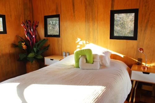 una camera da letto con un letto e una sedia verde di Tiny House with trekking circuit a San Cristóbal de Las Casas