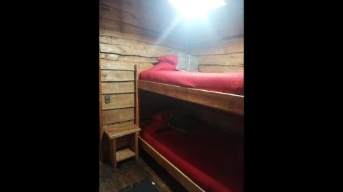 a bunk bed in a room with a light on it at Cabaa rstica 2 maravillosa,con troncos nativos, con orilla de Ro Trancura in Pucón