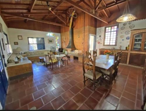 ein großes Wohnzimmer mit einem Tisch und einer Küche in der Unterkunft Passa Quatro- CASA INTEIRA RUSTICA para até 9 pessoas in Passa Quatro