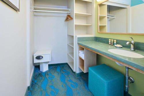 a bathroom with a sink and a mirror at Aston Waikiki Circle Hotel in Honolulu