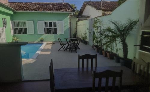 une terrasse avec des chaises, une table et une piscine dans l'établissement Casa com Piscina 200 m da Praia - São Sebastião, à São Sebastião