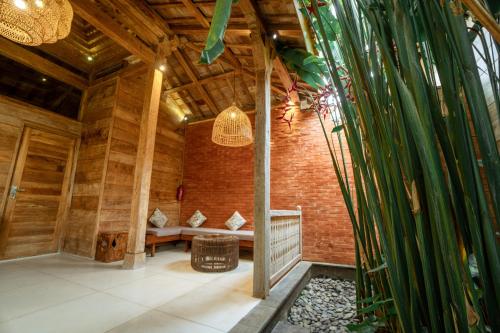 a room with a bench in a bamboo house at Rimbun Canggu Villa in Canggu