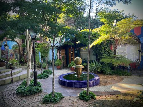 a fountain in the middle of a courtyard with trees at Rabbit Hole Hotel in Krugersdorp