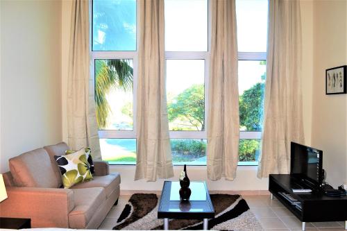 a living room with a couch and a large window at Luxury Escapes - Tranquil Retreat - Studio Apts near Metro and Mall - Discovery Gardens - SHAR & MCL in Dubai