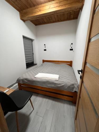 een slaapkamer met een bed, een bureau en een stoel bij Твоє Сколе in Skole