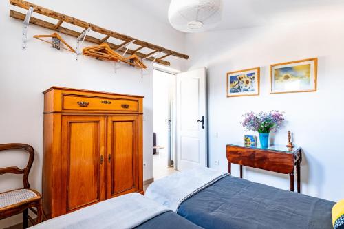 - une chambre avec un lit, une armoire en bois et une table dans l'établissement Comfortable Apartment Nyons Private Garden, Wellness, à Nyons