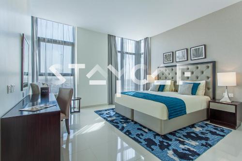 a bedroom with a bed and a desk with a desk at Staycae Holiday Homes - Celestia in Dubai
