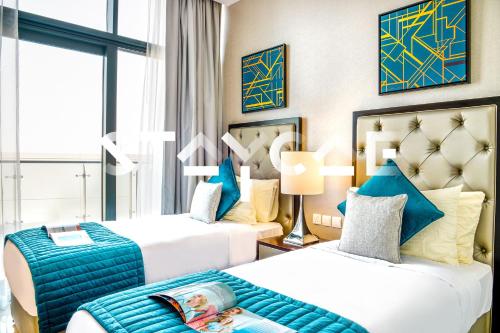a hotel room with two beds with blue accents at Staycae Holiday Homes - Celestia in Dubai