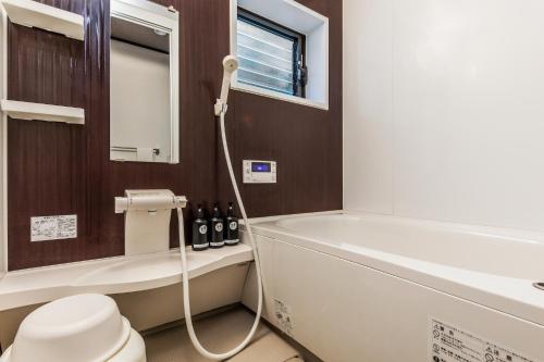 a bathroom with a tub and a toilet and a sink at Shiki Homes SEN in Kyoto