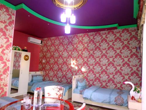 a room with pink and purple walls and a table at Tubram S Ailəvi Qonaq Evi in Sheki