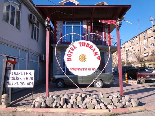 a sign for a restaurant in front of a building at Tubram S Ailəvi Qonaq Evi in Sheki
