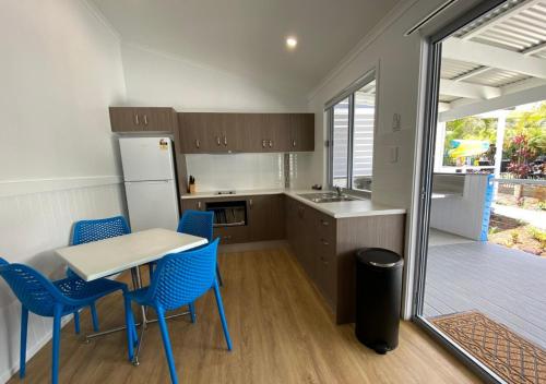 a kitchen with blue chairs and a table and a refrigerator at Nobby Beach Holiday Village in Gold Coast