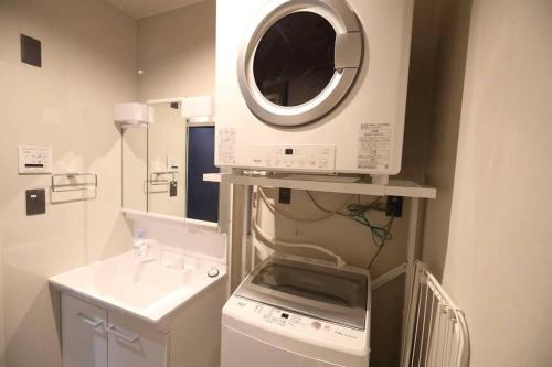 a kitchen with a washing machine and a microwave at White Crystal RoomB in Fukuoka