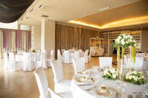 a banquet hall with white tables and white chairs at Hotel Panorama in Thessaloniki