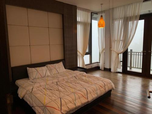 ein Schlafzimmer mit einem Bett in einem Zimmer mit Fenstern in der Unterkunft CA Homestay Borneo Highland in Kampong Teng