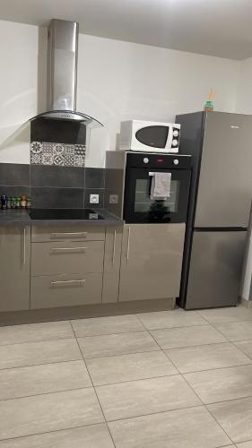 une cuisine avec une cuisinière et un réfrigérateur dans l'établissement Superbe appartement, à Roanne