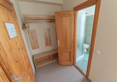 uma casa de banho com um chuveiro e uma porta de madeira em Hotel Katrina em Cēsis