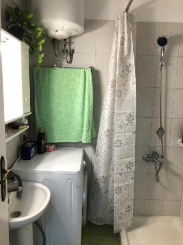y baño con cortina de ducha y lavamanos. en Sun Beach Apartment en Anavissos