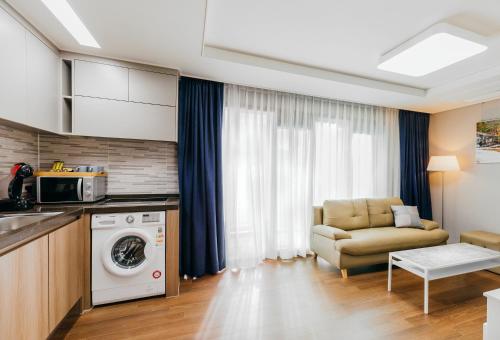 a kitchen and living room with a washing machine and a couch at Risen Ocean Park Hotel in Sokcho