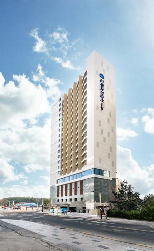 a tall white building with a sign on it at Risen Ocean Park Hotel in Sokcho