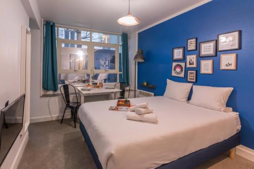 a blue bedroom with a bed and a desk at Apartments WS Montmartre - Sacré Coeur in Paris