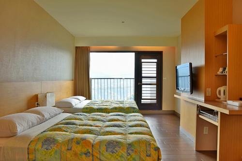 Habitación de hotel con 2 camas y TV de pantalla plana. en 阿里山梅園樓觀景飯店, en Fenchihu