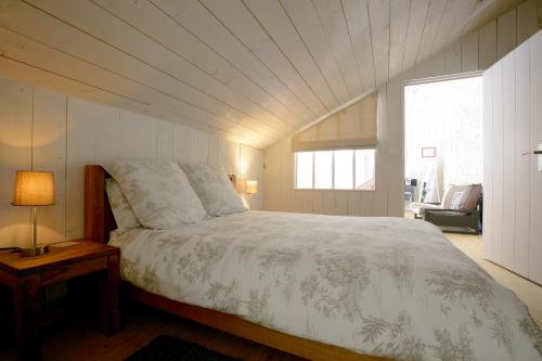 サント・マリー・ド・レにあるLa Maison Balnéaireのベッドルーム1室(ベッド1台、テーブル、窓付)