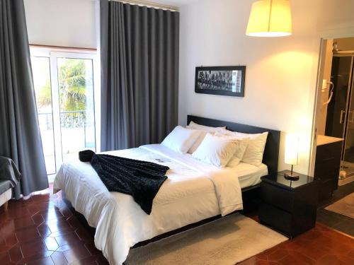 sypialnia z łóżkiem z białą pościelą i oknem w obiekcie HOTEL BOUTIQUE a ESPLANADA w mieście Castelo Branco